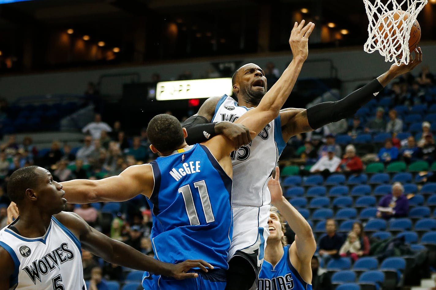 Minnesota Timberwolves forward Shabazz Muhammad (15) pushes the ball up to the basket against Dallas Mavericks center JaVale McGee (11) in the first half of an NBA basketball game, Sunday, Jan. 10, 2016, in Minneapolis.