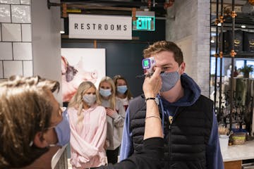 Grocer's Table employee Drew Sigel had his temperature checked before clocking in on Tuesday, part of a new health screening for employees. When the r