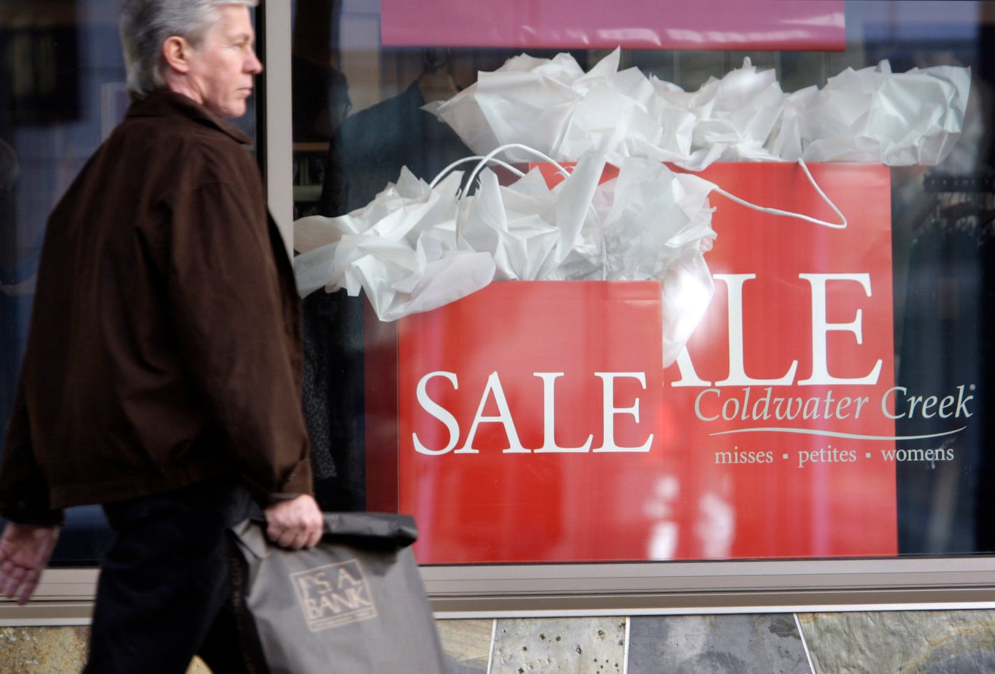 In this 2009 file photo, a shopper walks past a Coldwater Creek store in downtown Seattle. The women's clothing retailer filed for Chapter 11 bankruptcy protection Friday, April 11, 2014, after failing to find a potential buyer or a source of capital to help fund its turnaround efforts.