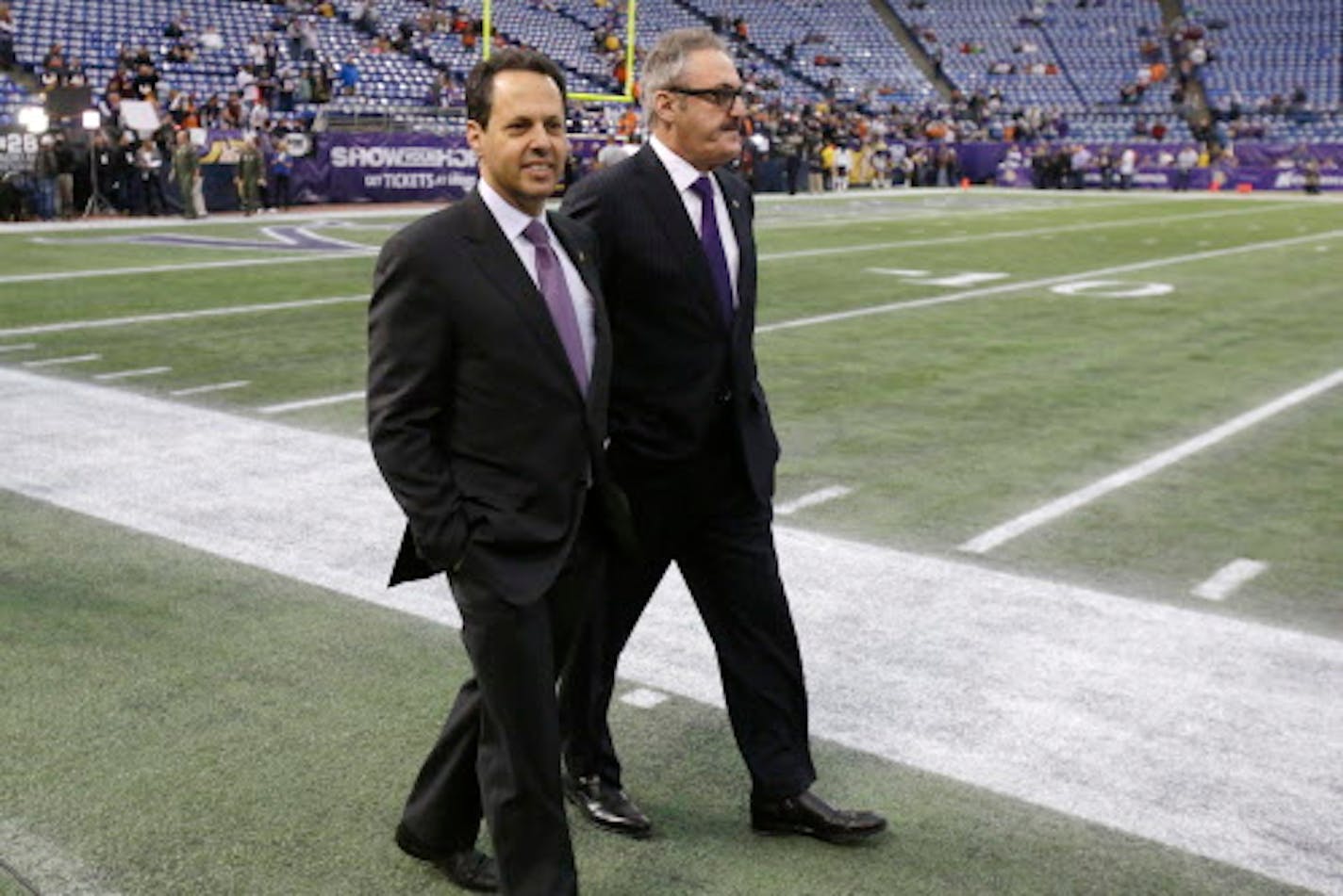 FILE - In this Sunday, Dec. 1, 2013 file photo, Minnesota Vikings owners Mark, left, and Zygi Wilf walk on the field prior to the first half of an NFL football game in Minneapolis. The majority owners of the Minnesota Vikings are joining a group trying to bring a Major League Soccer expansion franchise to Nashville. Mark, Zygi and Leonard Wilf are minority owners in the Nashville project, according to Nashville Soccer Holdings CEO John R. Ingram, Tuesday, Aug. 8, 2017. (AP Photo/Jim Mone, File)