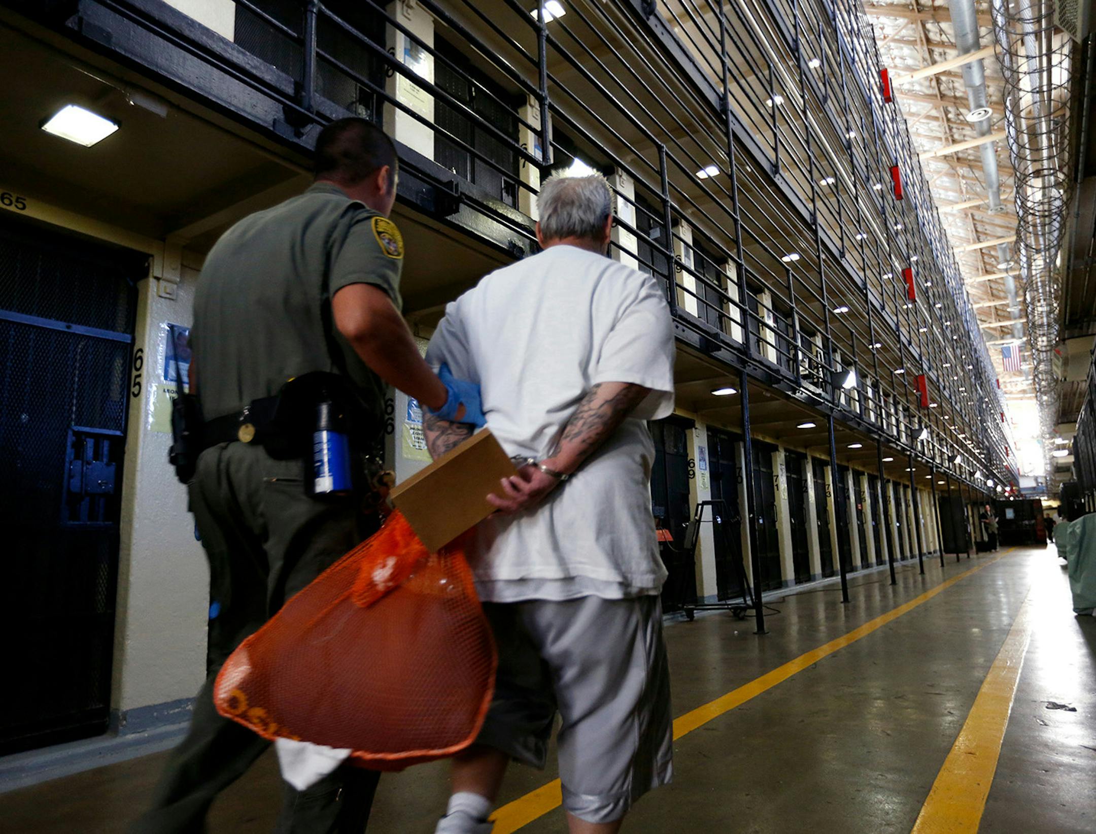 A death row inmate is escorted back to his East Block cell after spending time in the yard at San Quentin State Prison, San Quentin, Calif., on August 16, 2016. (Gary Coronado/Los Angeles Times/TNS)