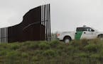 FILE - In this Nov. 13, 2016 file photo, a U.S. Customs and Border Patrol agent passes along a section of border wall in Hidalgo, Texas. The GOP-contr