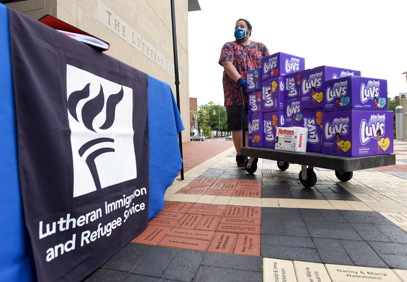 Berny Lopez, an operations specialist for Lutheran Immigration and Refugee Service, moves donated diapers at the organization's drop-off site for items to help refugees from Afghanistan, Tuesday, Aug. 31, 2021, in Baltimore. (AP Photo/Steve Ruark)