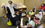 Qorsho Hassan demonstrated to her students how to push through something as she read to them Friday morning at Echo Park Elementary School. ] ANTHONY 