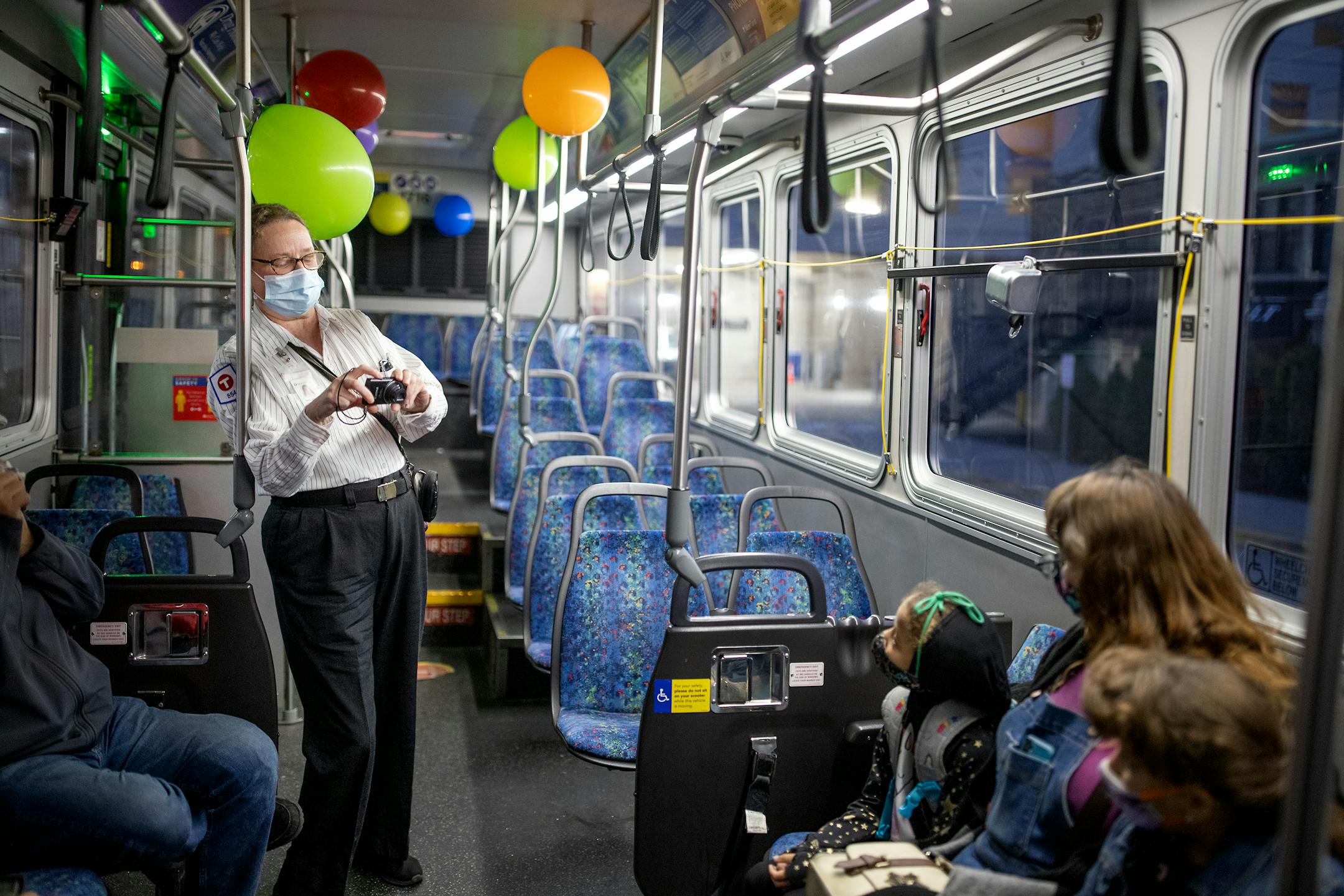 Melanie Benson took photos of her friends an neighbors Henry and Rebekha Gertcher  with their twin daughters Emma and Zoe, 7, as they joined her for a ride on her bus to celebrate her anniversary, Monday, October 11, 2021 between Minneapolis and St. Paul.