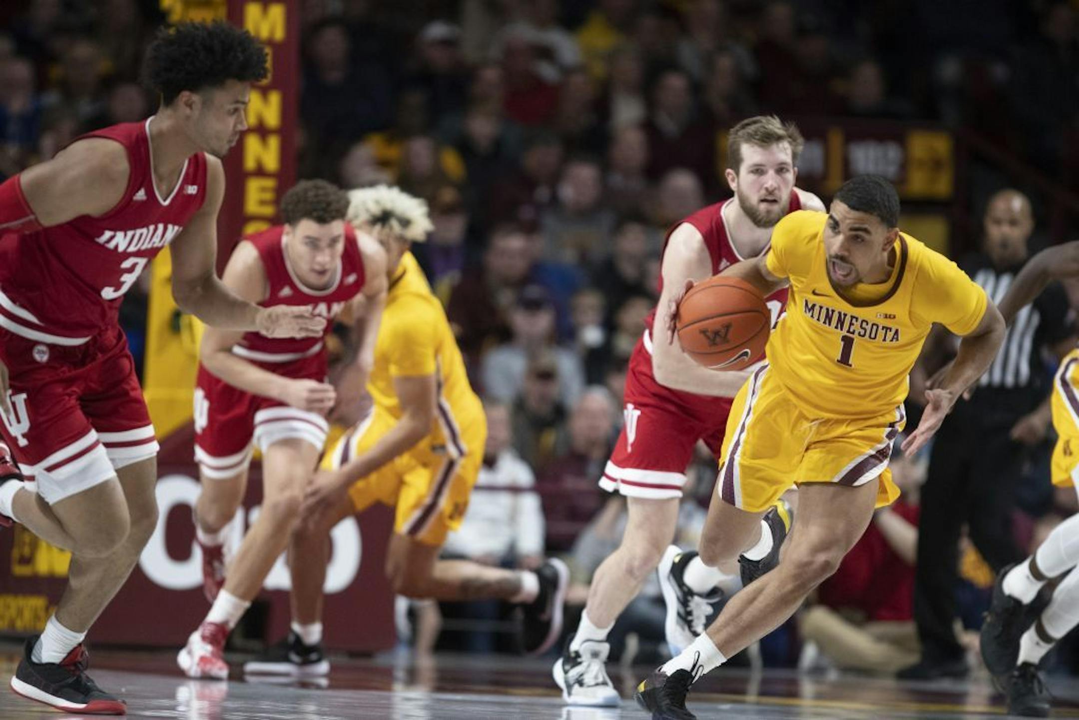 Minnesota Gophers guard Tre' Williams (1) dribbled the ball down court in the first half .