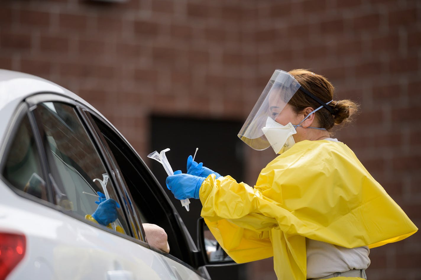 Elizabeth Santoro, a medic with the Minnesota Air National Guard 133rd Medical Group, administered a free COVID-19 test to a passenger at the drive-up testing site behind the Minneapolis Armory, Saturday, May 23, 2020, in Minneapolis. (Aaron Lavinsky/Star Tribune via AP) Aaron Lavinsky Publication Date: June 6, 2020