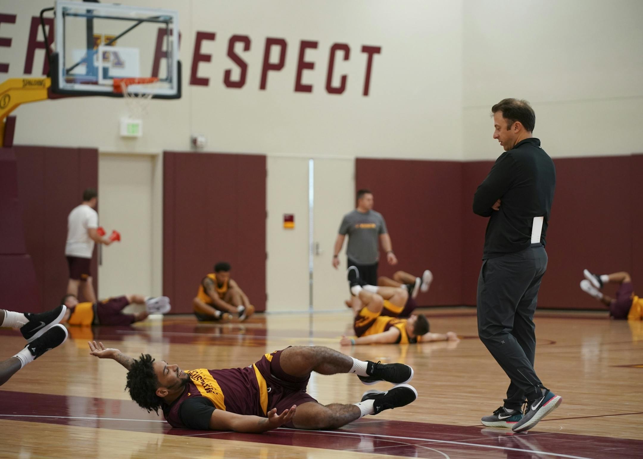 U of M men's head basketball coach Richard Pitino spoke with Jordan Murphy while the team stretched at the start of practice.