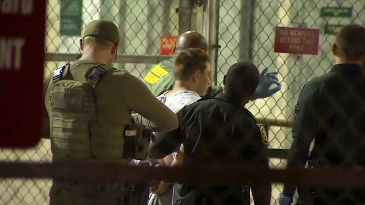 In this frame grab from video provided by WPLG-TV, police take Nikolas Cruz into Broward County jail on Thursday, Feb. 15, 2018 in Fort Lauderdale, Fla. Cruz was charged with 17 counts of premeditated murder Thursday morning after being questioned for hours by state and federal authorities. (WPLG-TV via AP)