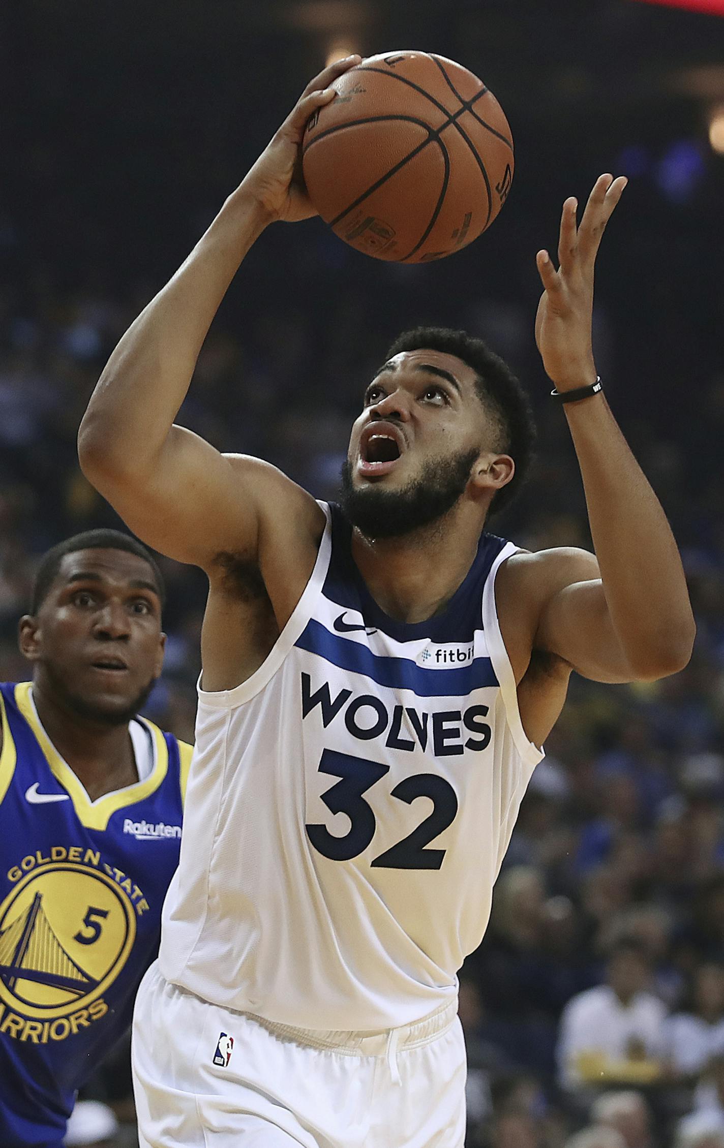 Minnesota Timberwolves' Karl-Anthony Towns, right, looks for a shot next to Golden State Warriors' Kevon Looney (5) during the first half of an NBA basketball game Friday, Nov. 2, 2018, in Oakland, Calif. (AP Photo/Ben Margot)