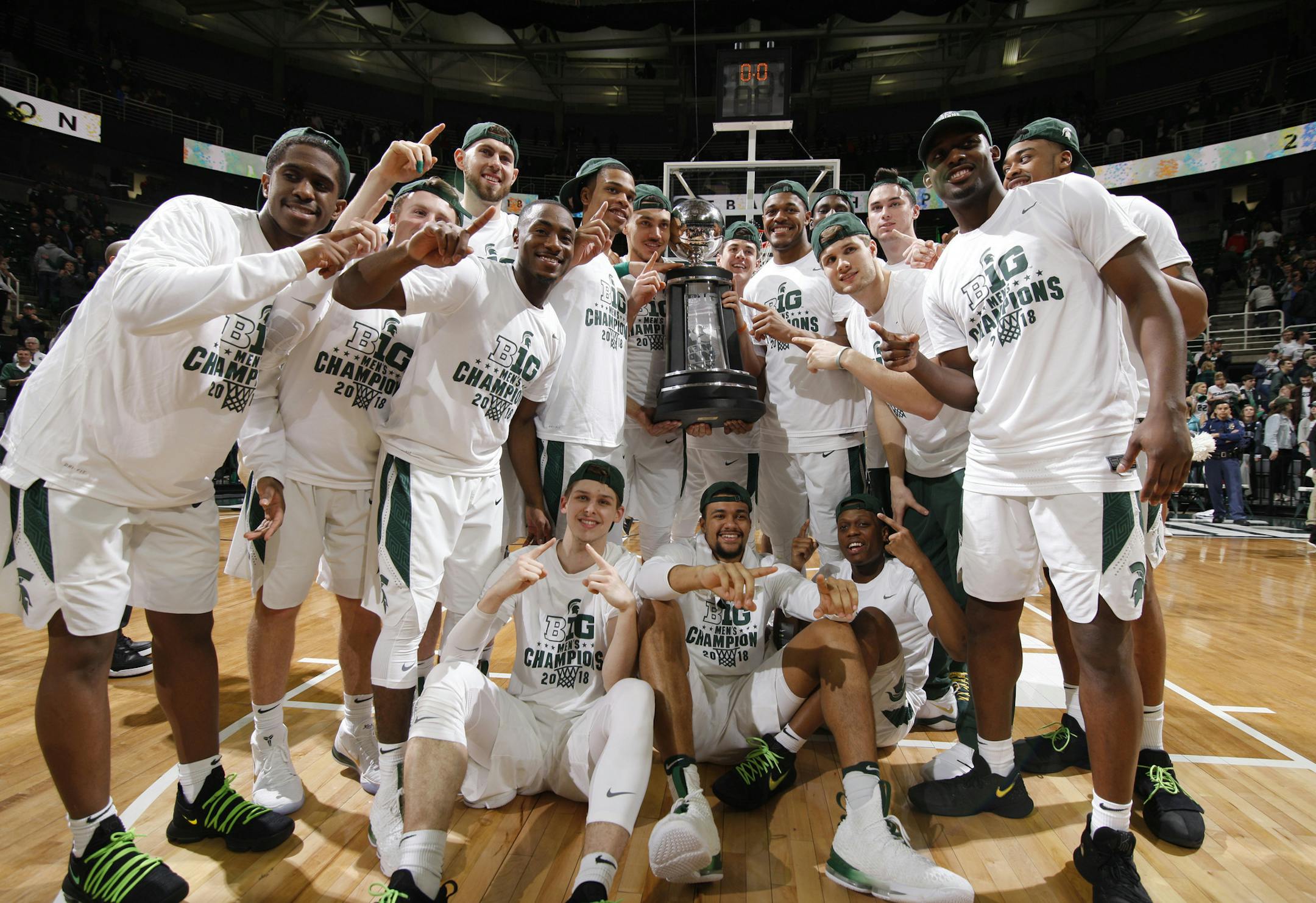 Michigan State players pose with thei Big Ten championship trophy following an NCAA college basketball game against Illinois, Tuesday, Feb. 20, 2018, in East Lansing, Mich. Michigan State won 81-61 to clinch at least a share of the title. (AP Photo/Al Goldis)