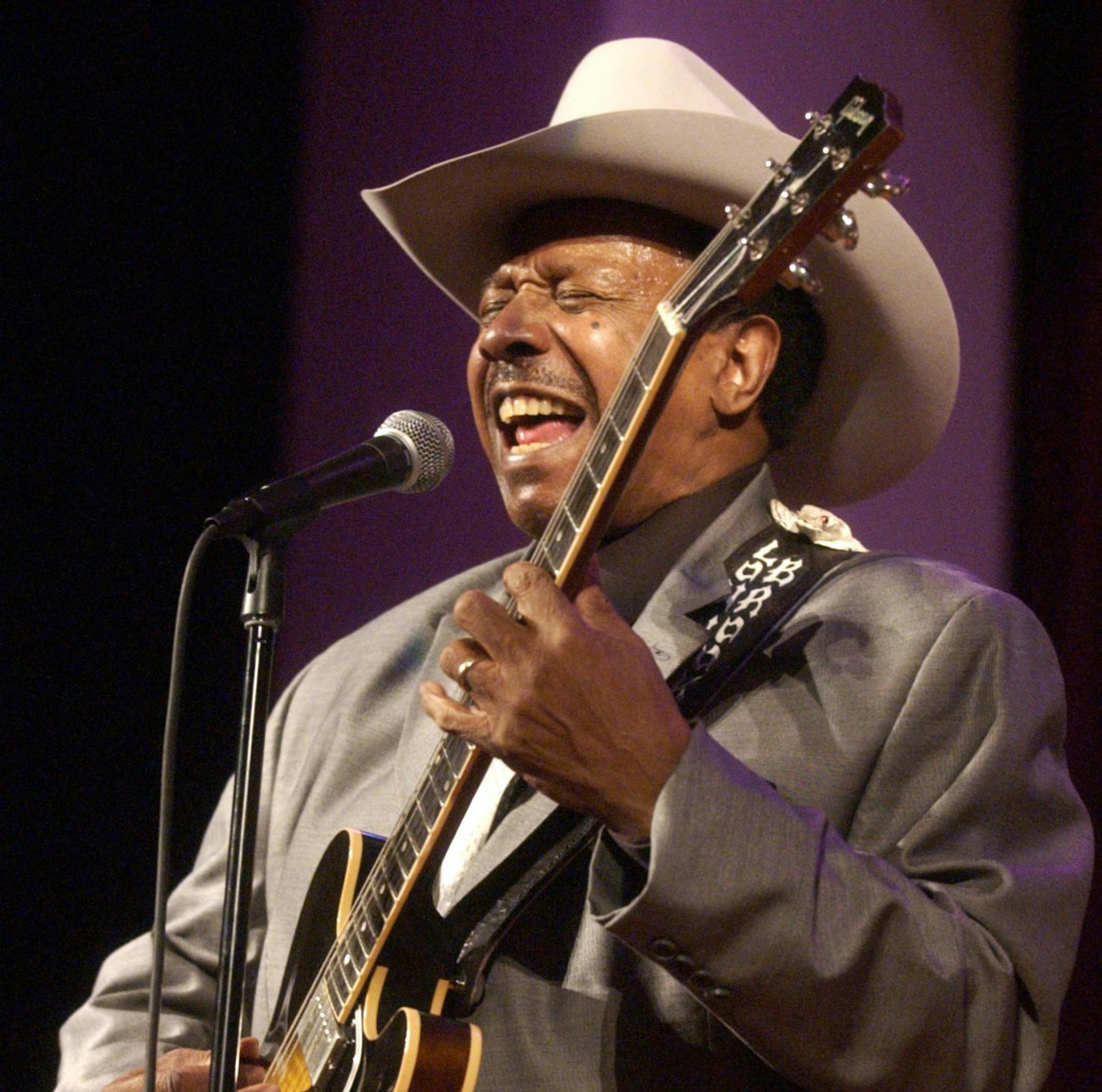 In this Feb. 13, 2005 photo, guitarist Lonnie Brooks performs with the Chicago Jazz Ensemble at the Simpson Theatre in the Field Museum in Chicago. Brooks, whose relationship with his adopted hometown was cemented by his hit recording of Robert Johnson's "Sweet Home Chicago," has died at age 83. (Terrence Antonio James/Chicago Tribune via AP)