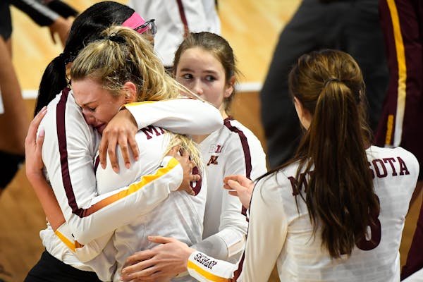 Minnesota setter Samantha Seliger-Swenson (13) was comforted by teammates as she hugged middle blocker Taylor Morgan following their 3-1 loss against 