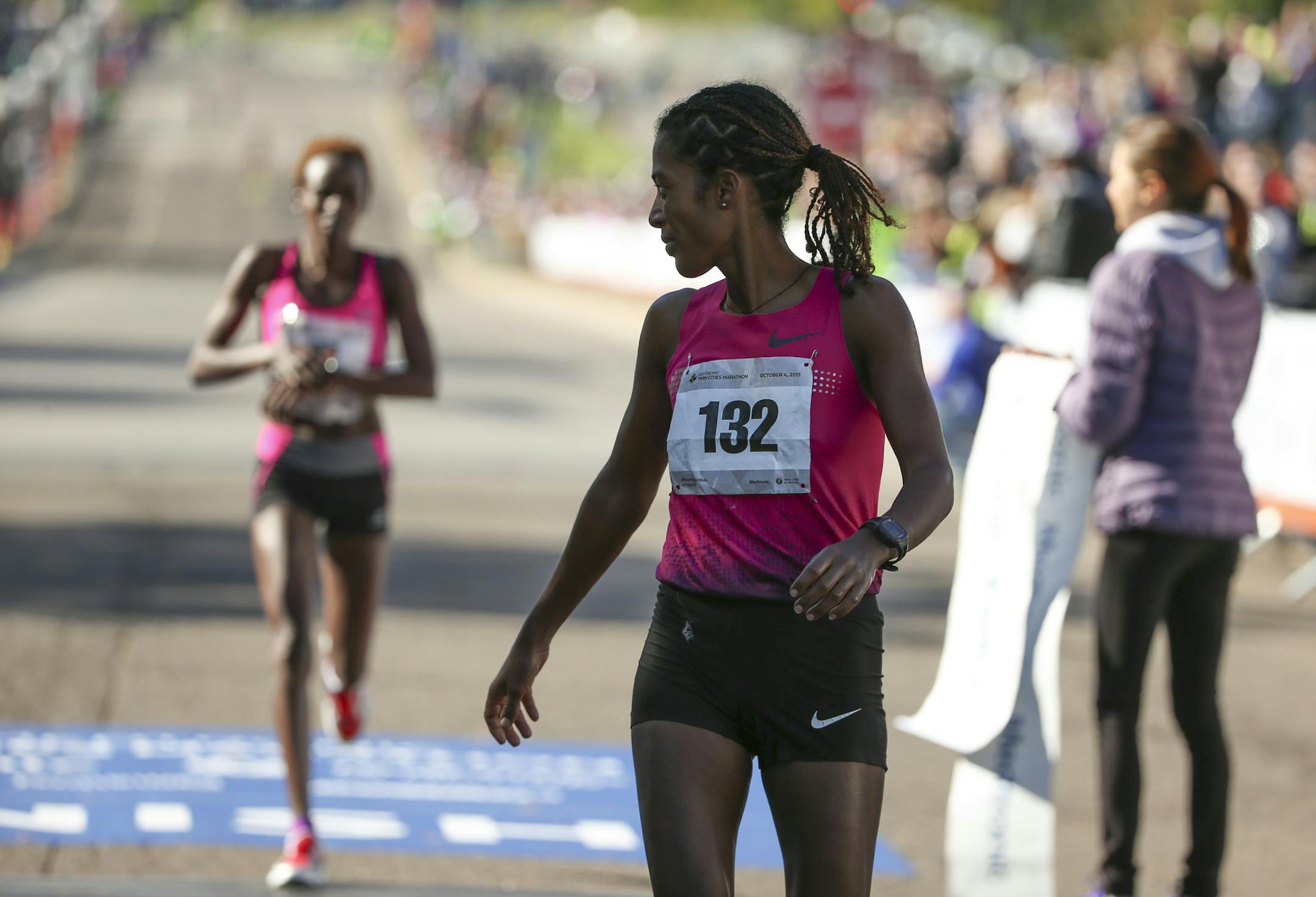 Women's winner Serkalem Abraha glanced back at second place finisher Jane Kibii as she crossed the finish line Sunday morning. ] JEFF WHEELER ï jeff.wheeler@startribune.com More than 11,000 runners started the Twin Cities Marathon Sunday morning, October 4, 2015 in Minneapolis.