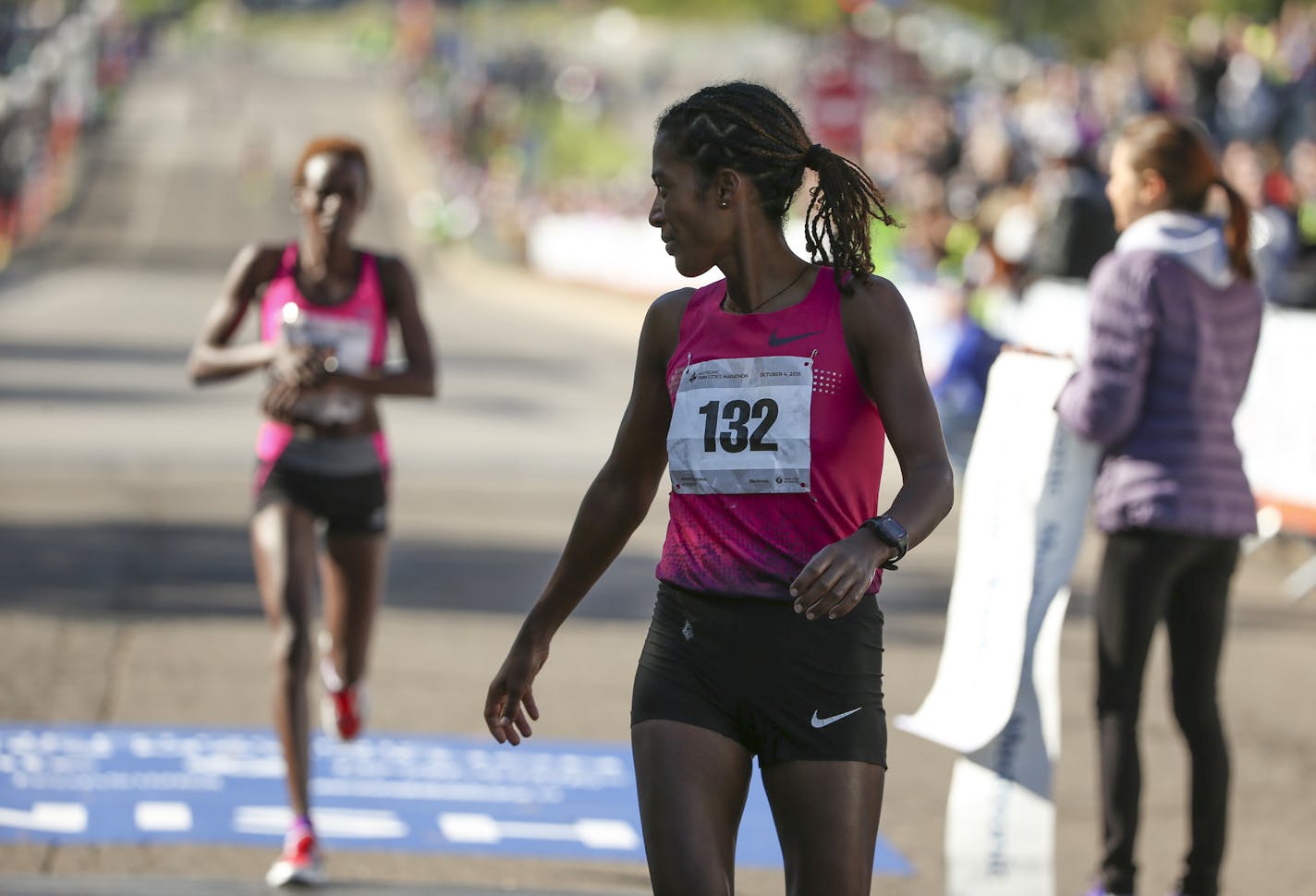 Women's winner Serkalem Abraha glanced back at second place finisher Jane Kibii as she crossed the finish line Sunday morning. ] JEFF WHEELER &#xef; jeff.wheeler@startribune.com More than 11,000 runners started the Twin Cities Marathon Sunday morning, October 4, 2015 in Minneapolis.