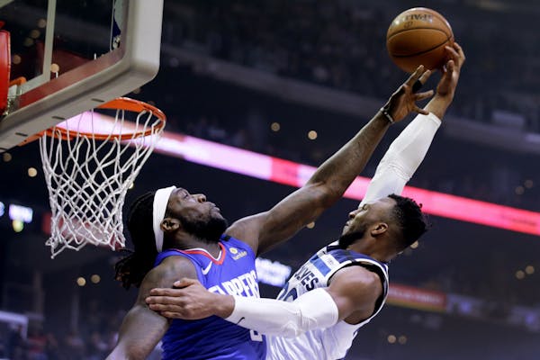 Minnesota Timberwolves guard Josh Okogie, right, shoots over Los Angeles Clippers forward Montrezl Harrell during the first half of an NBA basketball 