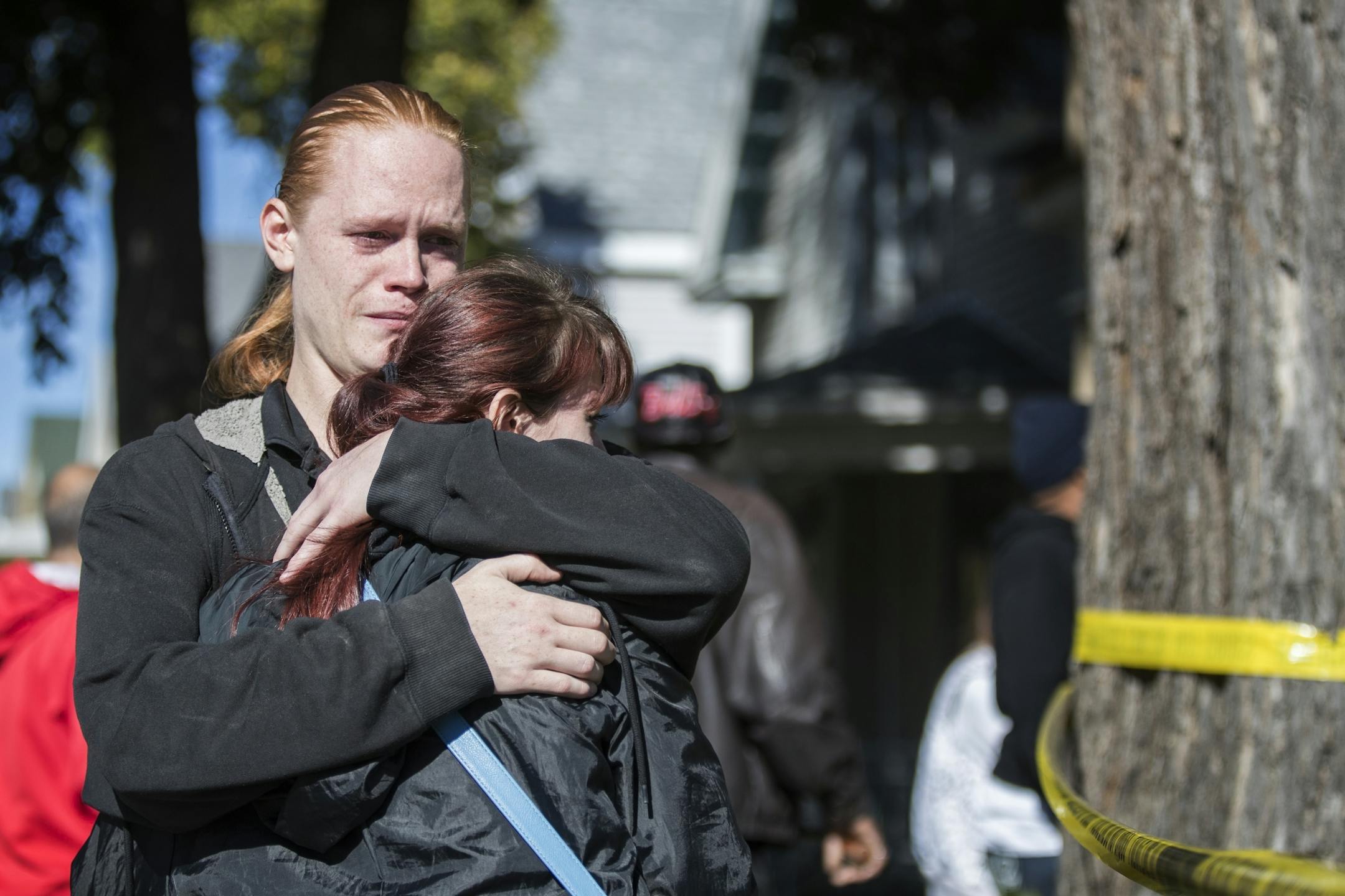 Jesse Lindstrom, facing camera, and his sister Jasmine Lindstrom, hug each other while waiting at the scene of the shooting. They are the aunt and uncle of the baby who was killed.