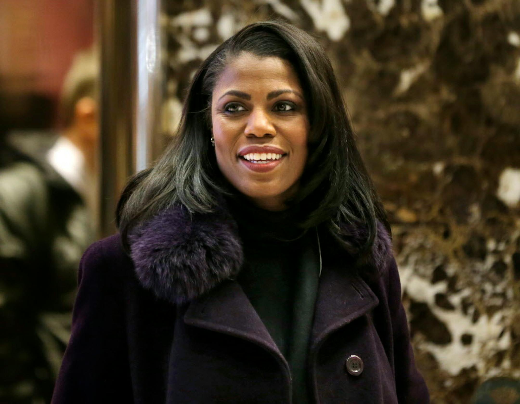 In this Dec. 13, 2016 photo, Omarosa Manigault smiles at reporters as she walks through the lobby of Trump Tower in New York.