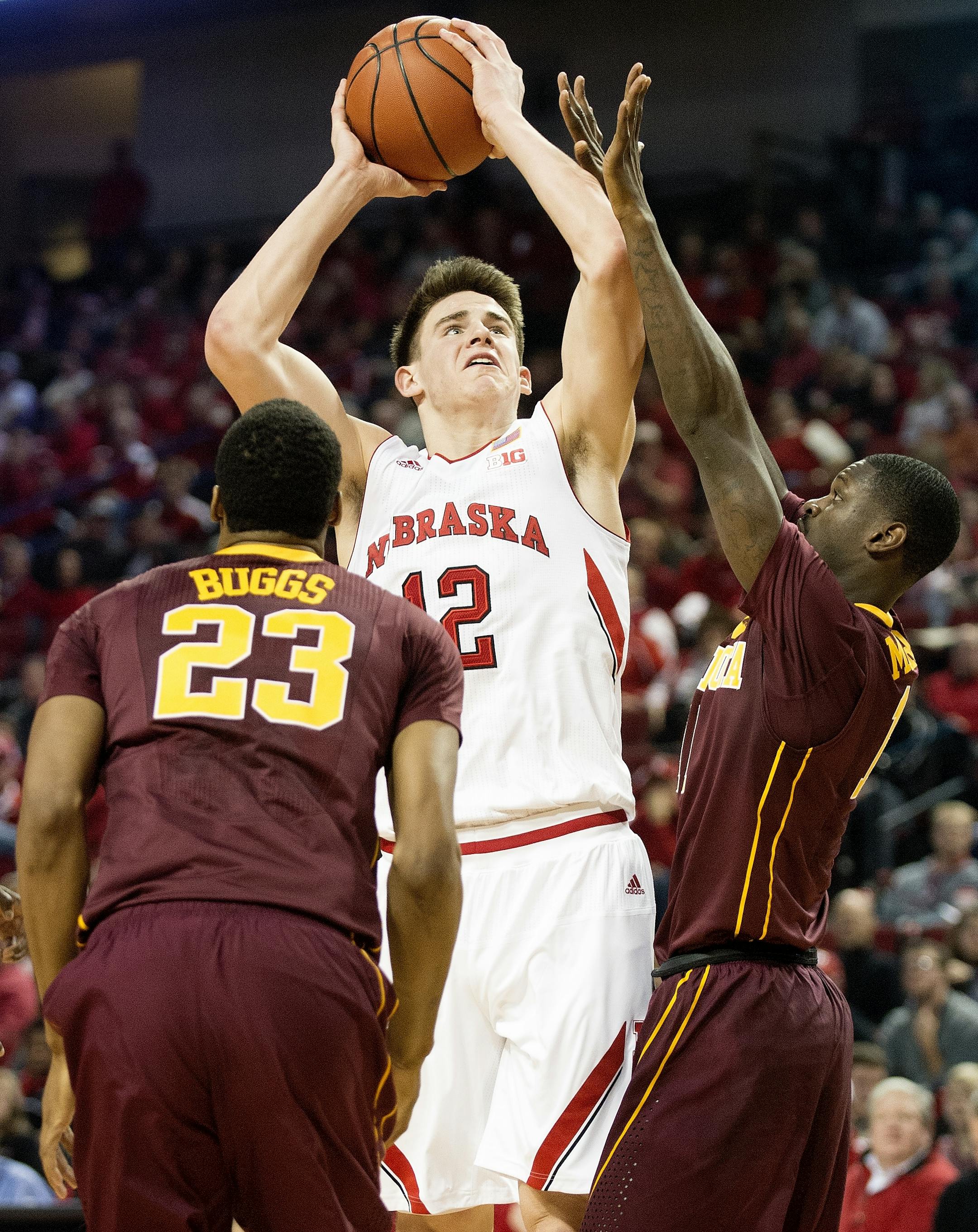 Nebraska forward Michael Jacobson (12) shoots between Minnesota forward Charles Buggs (23) and Carlos Morris during the second half of an NCAA college basketball game in Lincoln, Neb., Tuesday, Jan. 12, 2016. (Francis Gardler/The Journal-Star via AP) LOCAL TELEVISION OUT; KOLN-TV OUT; KGIN-TV OUT; KLKN-TV OUT; MANDATORY CREDIT