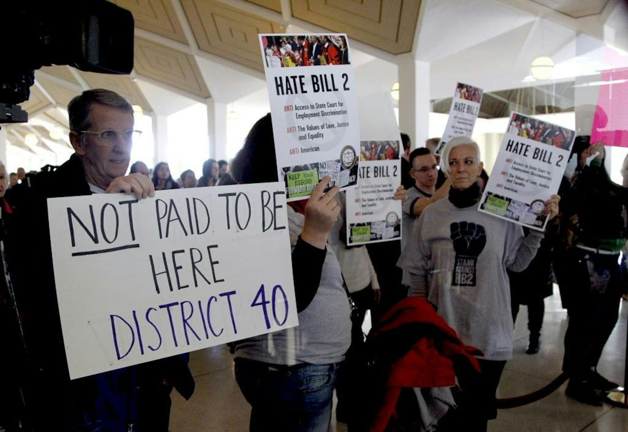 Opponents of HB2 hold signs outside the North Carolina House chambers gallery as the North Carolina General Assembly convenes for a special session at the Legislative Building in Raleigh, N.C. on Wednesday, Dec. 21, 2016. North Carolina's legislature reconvened Wednesday to decide whether enough lawmakers are willing to repeal a 9-month-old law that limited LGBT rights, including which bathrooms transgender people can use in public schools and government buildings.