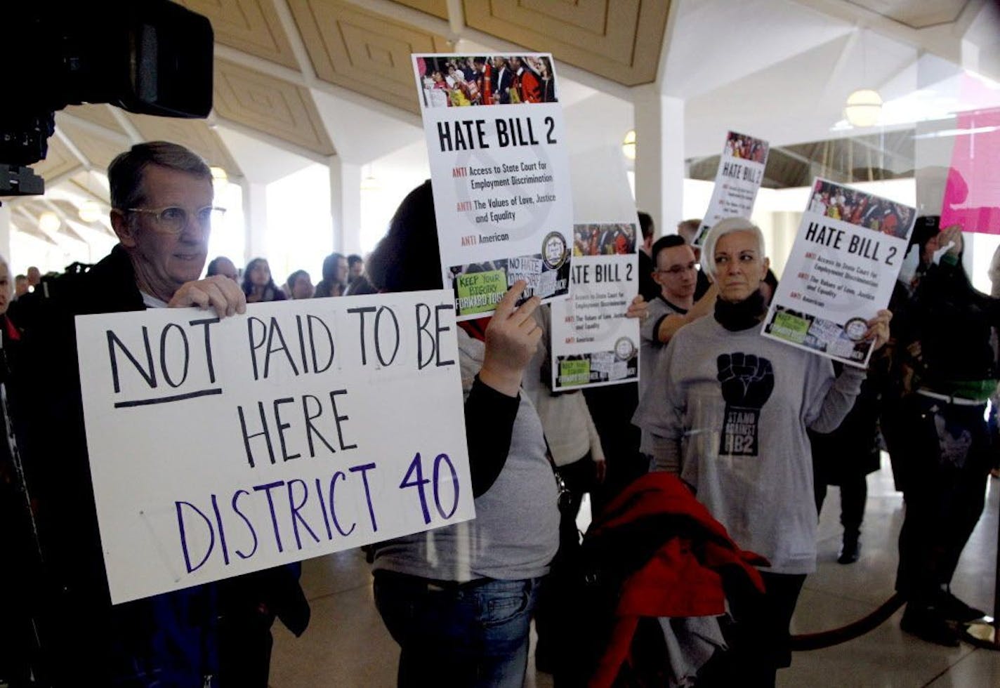 Opponents of HB2 hold signs outside the North Carolina House chambers gallery as the North Carolina General Assembly convenes for a special session at the Legislative Building in Raleigh, N.C. on Wednesday, Dec. 21, 2016. North Carolina's legislature reconvened Wednesday to decide whether enough lawmakers are willing to repeal a 9-month-old law that limited LGBT rights, including which bathrooms transgender people can use in public schools and government buildings.