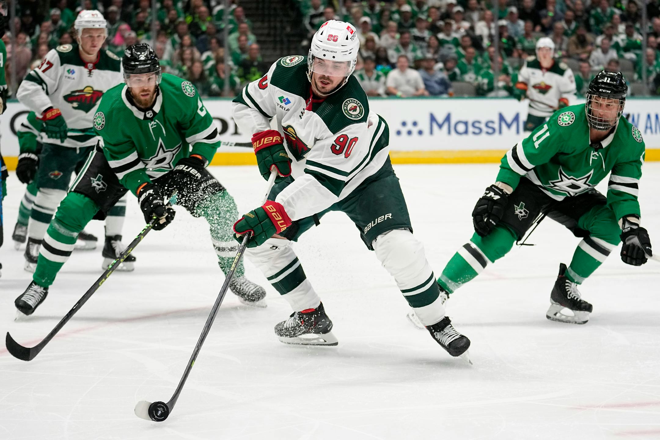 Minnesota Wild left wing Marcus Johansson (90) handles the puck on an attack as Dallas Stars' Jani Hakanpaa, left, and Luke Glendening (11) defend in the second period of Game 1.
