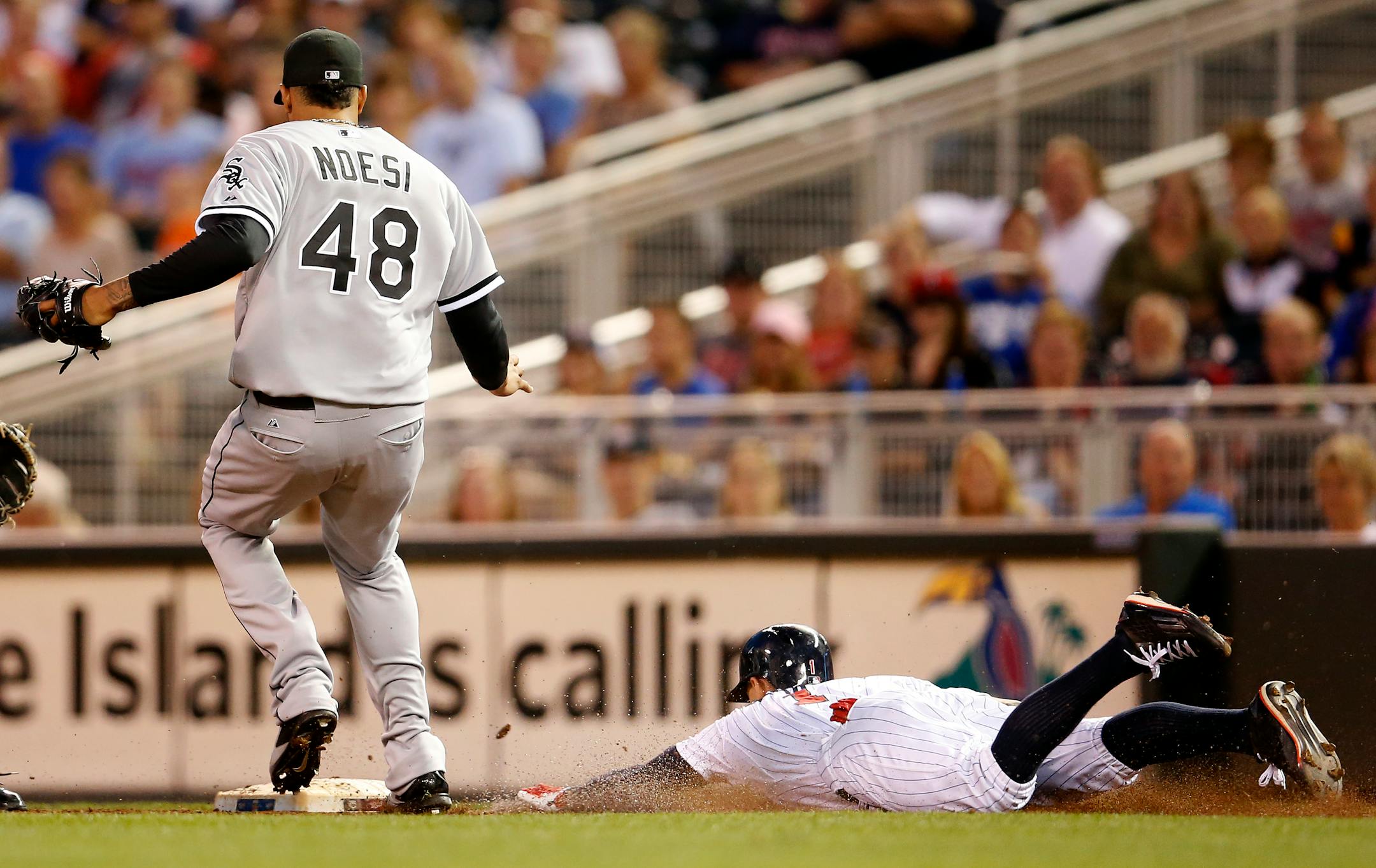 After bunting Jordan Schafer (1) slide into first base in front of Chicago White Sox starting pitcher Hector Noesi in the second inning. Schafer was called safe on the play.
