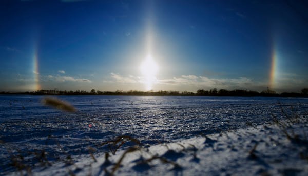 DAVID BREWSTER â€¢ dbrewster@startribune.com Sat. 01/01/11 Mankato : ] Sun dogs bracketed the setting sun over snow covered farm fields north of M
