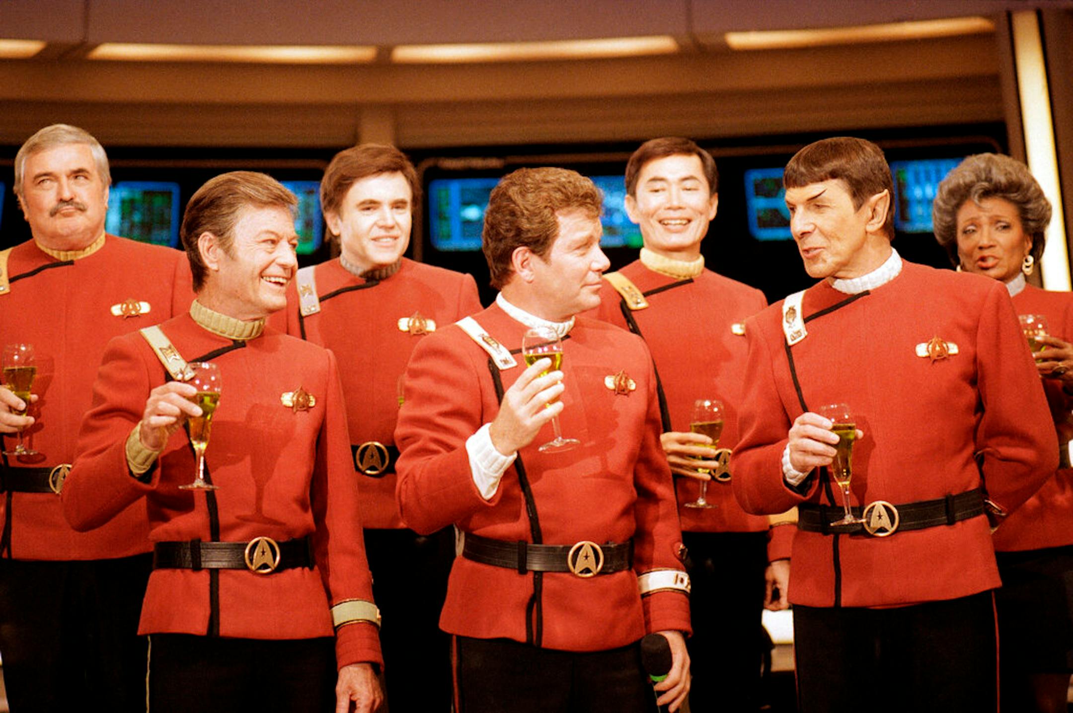 Members of the "Star Trek" crew, from left, in front: DeForest Kelley, William Shanter, and Leonard Nimoy, and back row from left: James Doohan, Walter Koenig, George Takei, and Nichelle Nichols toast the newest "Trek" film — in which Shatnter makes his directorial debut —"Star Trek V: The Final Frontier," during a news conference at Paramount Studios in Los Angeles, Dec. 28, 1988. (AP Photo/Bob Galbraith)