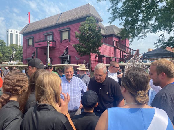 USDA Sec. Tom Vilsack, in black, visited with a dairy farm family, including Princess Kay of the Milky Way Emma Kuball, at the Minnesota State Fair on