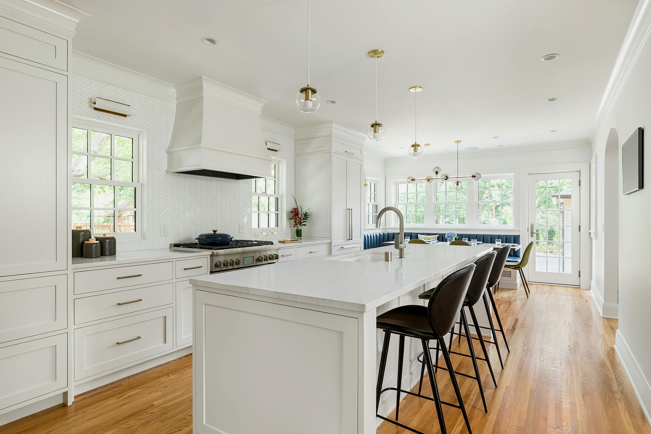 Angle view of white kitchen with built-in banquette and dining table