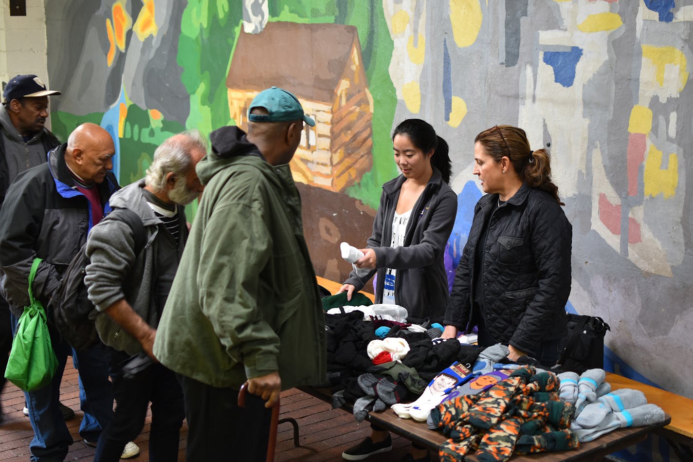 Volunteers for the nonprofit The Joy of Sox hand out new socks to those experiencing homelessness at St. John's Hospice in Philadelphia in 2018. (The Joy of Sox) ORG XMIT: 1447386