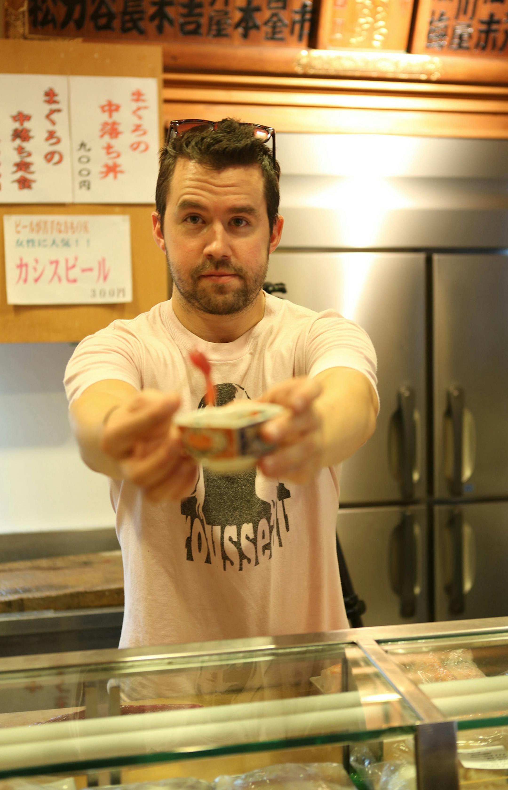 Photo by Mirra Fine, the Perennial Plate Daniel trying to convince Mirra to eat some fish, Tokyo