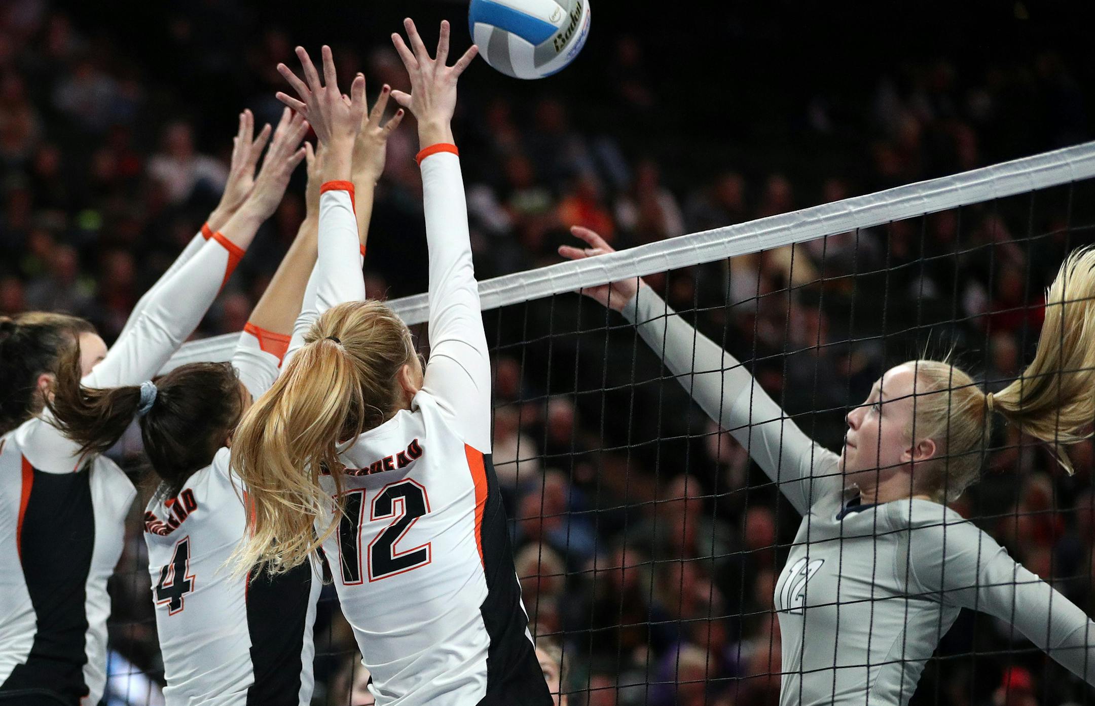 Champlin Park High School Hannah Prasky (12) sent the ball over the net as Moorhead High School players leapt to defend. ] ANTHONY SOUFFLE ï anthony.souffle@startribune.com Game action from a Class 3A volleyball quarterfinal volleyball match between Champlin Park High School and Moorhead High School Thursday, Nov. 9, 2017 at the Xcel Energy Center in St. Paul, Minn.