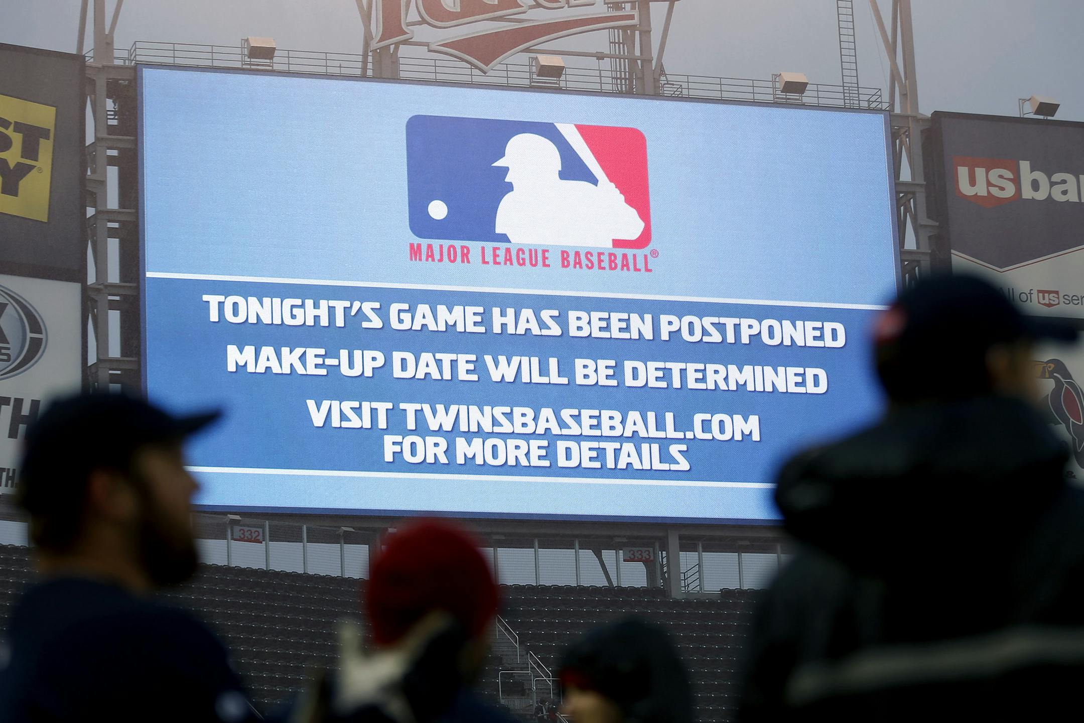 The grounds crew stood in the rain as a game postponement announcement was displayed on the scoreboard at Target Field on Wednesday night. ] CARLOS GONZALEZ cgonzalez@startribune.com April 17, 2013, Minneapolis, Minn., Target Field, MLB, Minnesota Twins vs. Los Angeles Angels