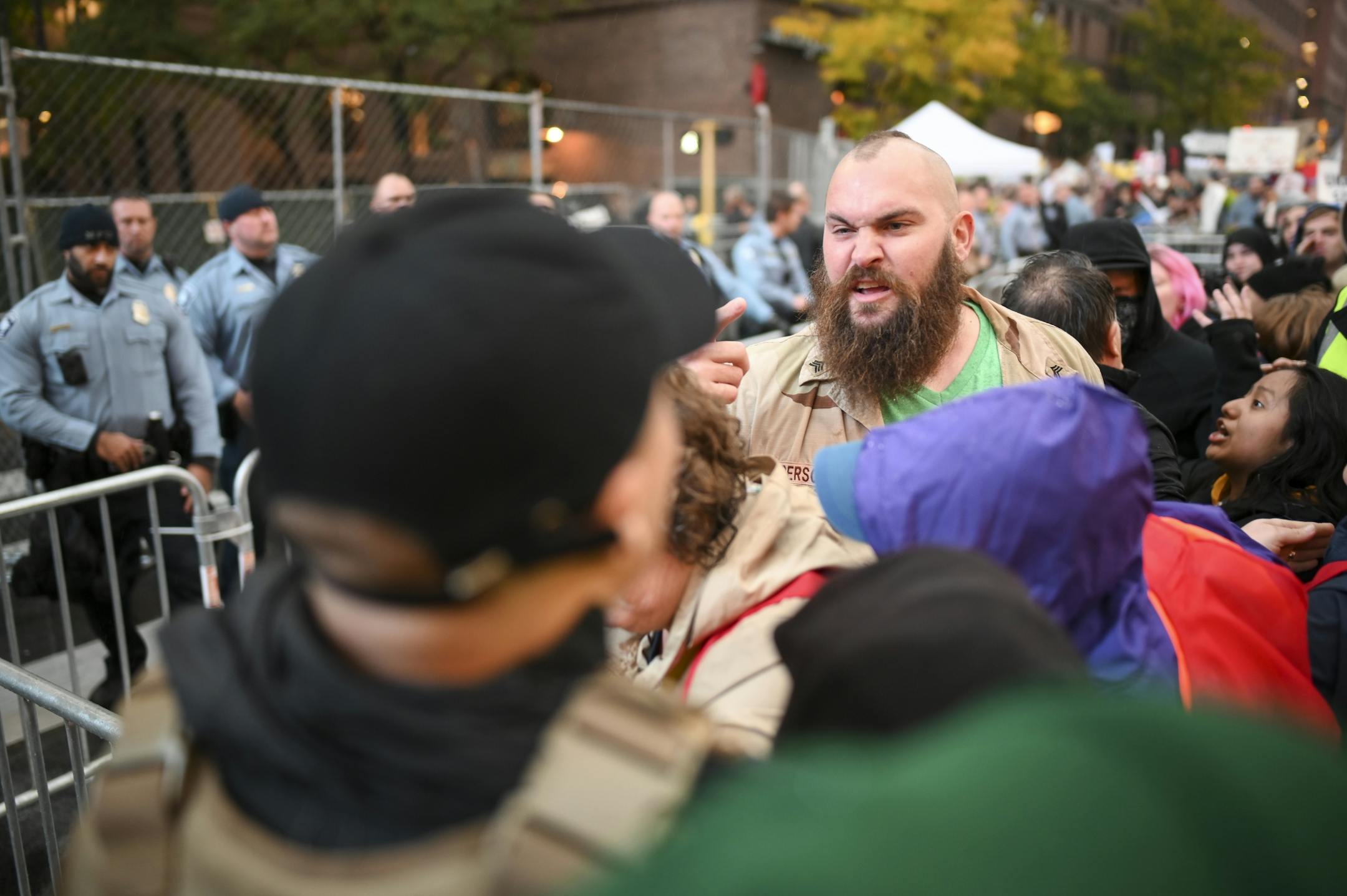 A Trump supporter, upper right, was met by an angry crowd of anti-Trump protesters as he walked near Target Center Thursday/.