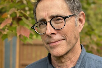 photo of author Leif Enger, with trees and a fence in background