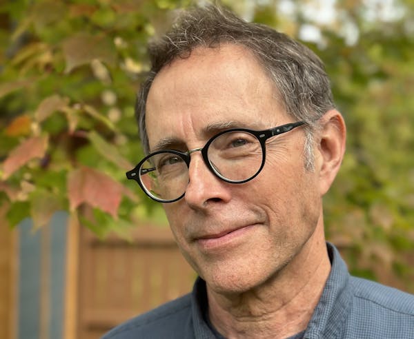 photo of author Leif Enger, with trees and a fence in background