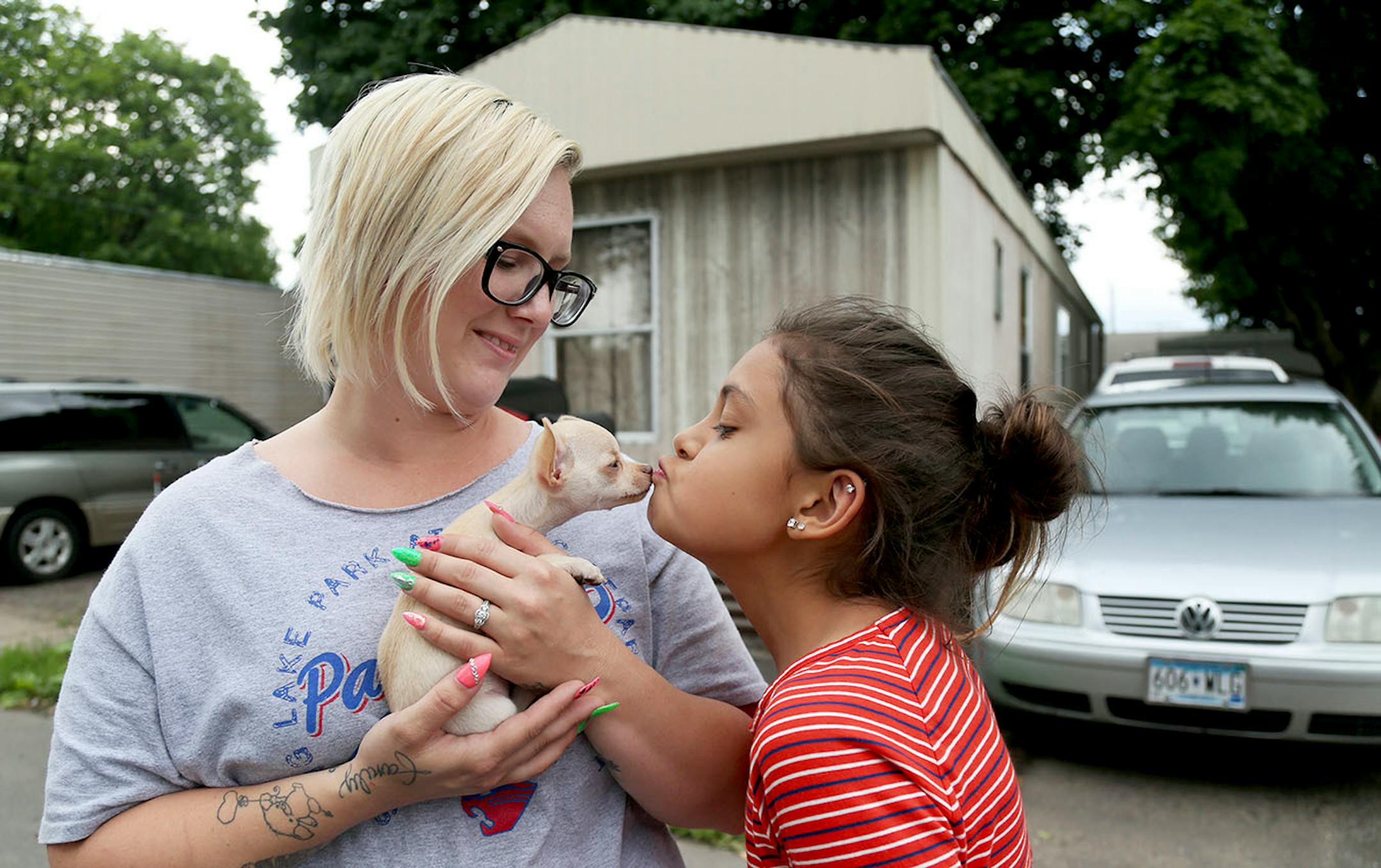Park Plaza mobile home park residents Rachael Davis, left, watches as her daughter Meadow Loch, 11, kisses their new puppy Val, an eight-week old chihuahua Wednesday, June 28, 2017, in Fridley, MN. Park Plaza has become a thriving cooperative community, owned by its residents and with no threat of closure.