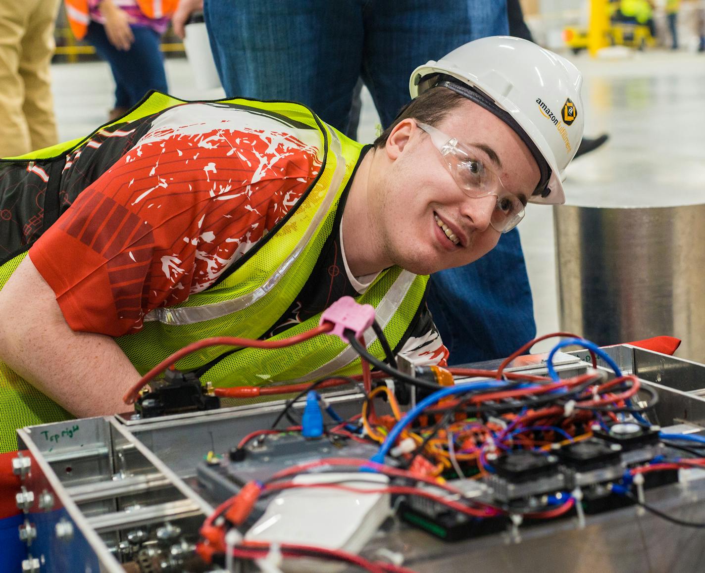 Scott Korum, senior at Shakopee Senior High School and members of Shakopee Robotics team, works on their personally designed robots in the not yet open Amazon Shakopee fulfillment center Friday morning. Amazon awarded the robotics team 10,000 dollars. ] Elizabeth Brumley special to the Star Tribune