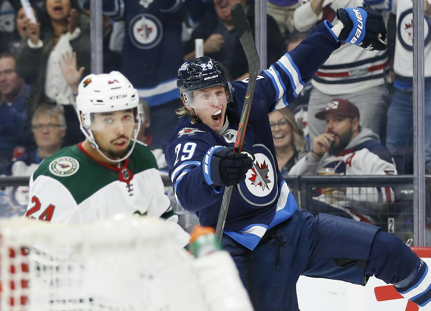 Winnipeg Jets' Patrik Laine (29) celebrates his goal as Minnesota Wild's Matt Dumba (24) skates by during the second period of an NHL hockey game Thursday, Oct. 10, 2019, in Winnipeg, Manitoba. (John Woods/The Canadian Press via AP)