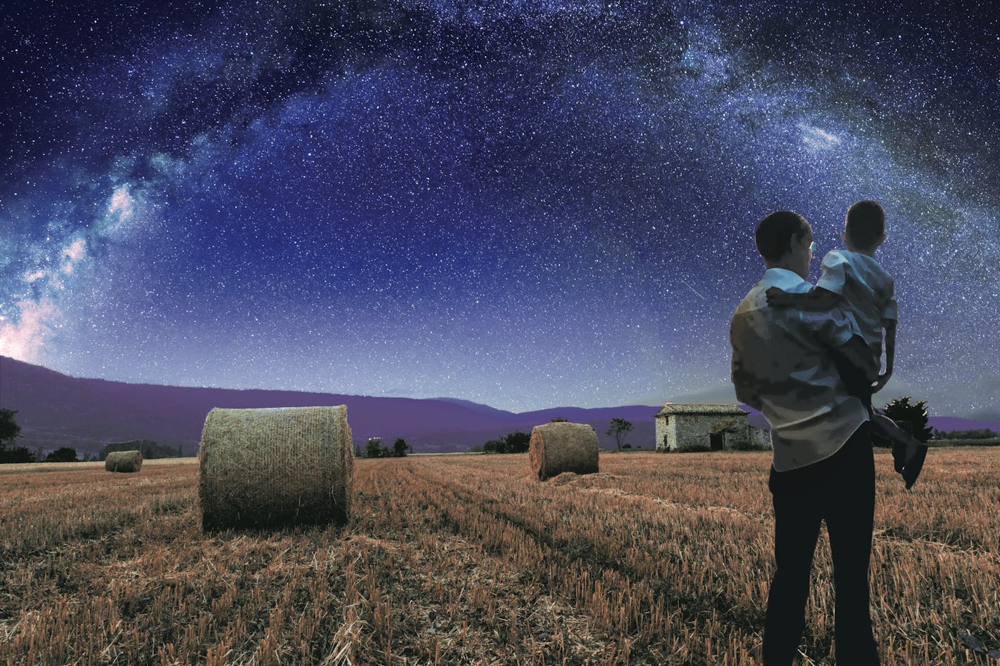 The night sky peppered with thousands of stars over farmland and straw bales in Provence, France