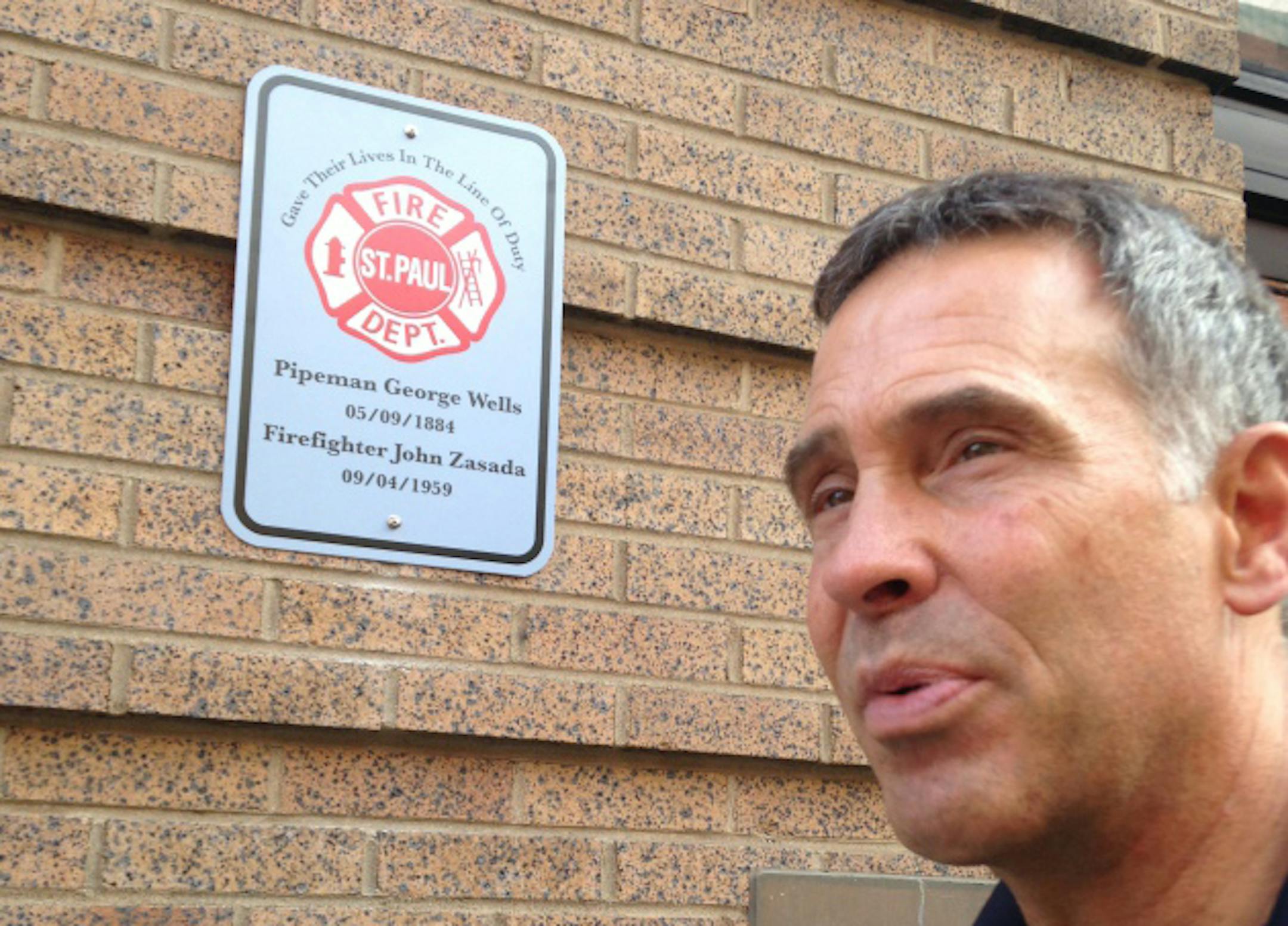 St. Paul fire Captain Bob Kippels talks about the memorial project while standing next to the first sign.