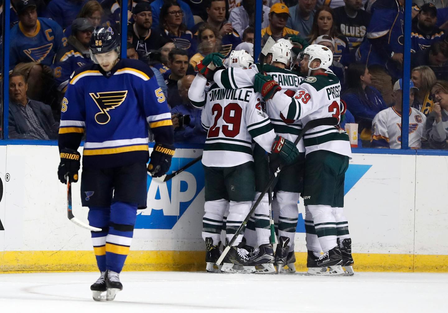 Members of the Minnesota Wild congratulate teammate Martin Hanzal, of the Czech Republic, on his goal as St. Louis Blues' Magnus Paajarvi, left, of Sweden, skates past during the second period in Game 4 of an NHL hockey first-round playoff series Wednesday, April 19, 2017, in St. Louis. (AP Photo/Jeff Roberson)