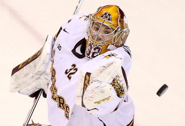 The University of Minnesota Gophers goalie Adam Wilcox knocks down a shot against Ohio State during the first period Friday, Feb. 6, 2015, at Mariucci