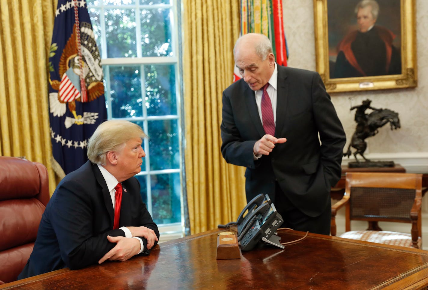 President Donald Trump listens to White House Chief of Staff John Kelly, right, following a meeting in the Oval Office.