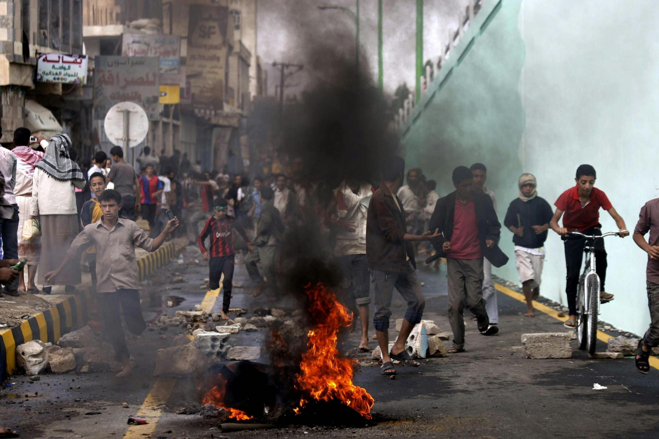 Protesters run as police, unseen, open fire into the air near the U.S. Embassy during a protest about a film ridiculing Islam's Prophet Muhammad, in Sanaa, Yemen, Thursday, Sept. 13, 2012.