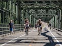 Bikers cross the historic Stillwater Lift Bridge, now exclusively for pedestrians and bikers.] Finally connected by a historic bridge and opened to th