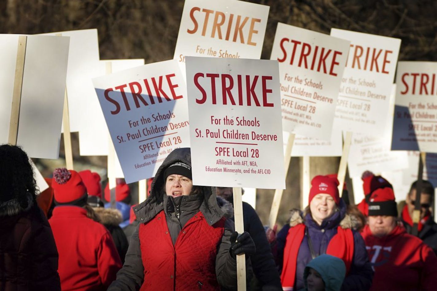 FILE - In this March 10, 2020 file photo, St Paul teachers picket outside Adams Elementary in St. Paul, Minn. The teachers union and Minnesota's second-largest school district reached a tentative contract agreement early Friday, March 13, ending a strike that began Tuesday and canceled classes for some 36,000 students. The union, which represents about 3,600 teachers and support staff, said it was in the best interest of all involved to settle the contract, given the uncertainty of possible scho