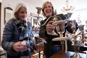 Owner Liz Murphy, right, showed customer Harriette “Cookie” Jandric a silver candle holder at Betty’s Antiques in St. Paul.